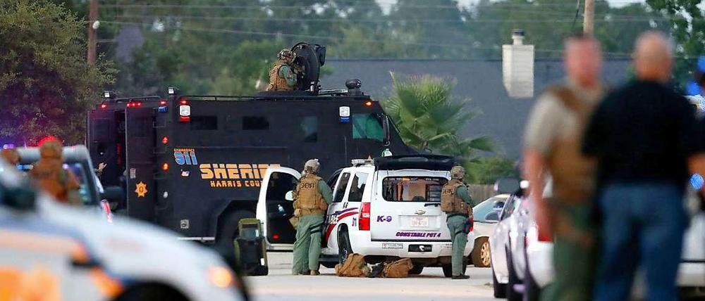 Polizisten und ein SWAT-Team warten in der Nähe des Tatortes. 