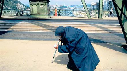 Land an Krücken. 1989, als der Eiserne Vorhang fiel, fühlte sich Ungarn im Aufwind. Inzwischen schlagen sich viele Menschen – wie diese greise Bettlerin auf der Freiheitsbrücke in Budapest – unterhalb der Armutsgrenze durch.