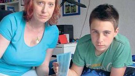 Niklas und seine Mutter schauen sich das Album mit den Ferienbildern an.