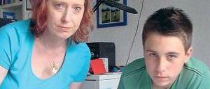 Niklas und seine Mutter schauen sich das Album mit den Ferienbildern an.