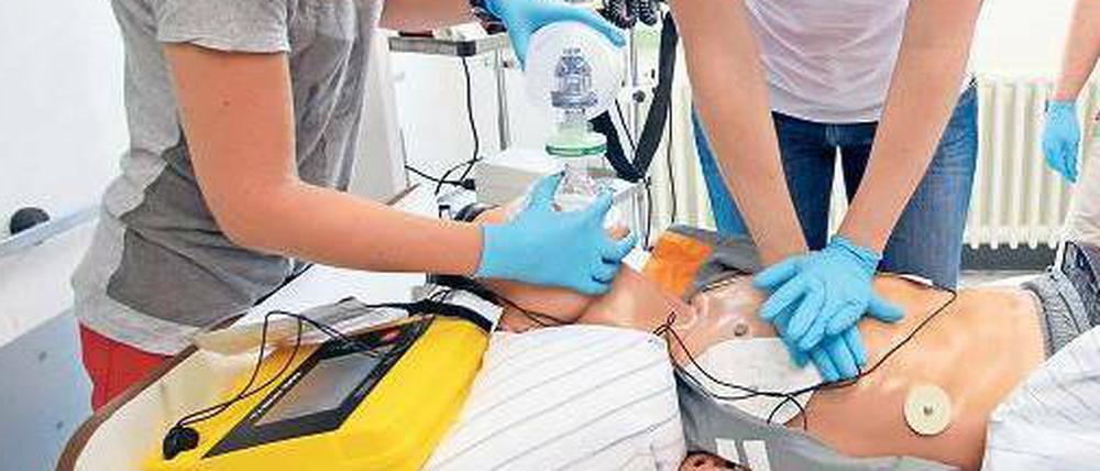 Zwei Medizinstudentinnen üben an einer Puppe, einen Patienten wiederzubeleben.
