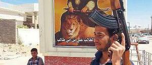 Kampfbereit: Ein Schiit patrouilliert vor einen Denkmal in Kirkuk. 