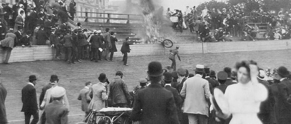 Ein brennendes Motorrad hängt über der Balustrade der Zuschauertribüne der Radrennbahn an der Potsdamer Straße.