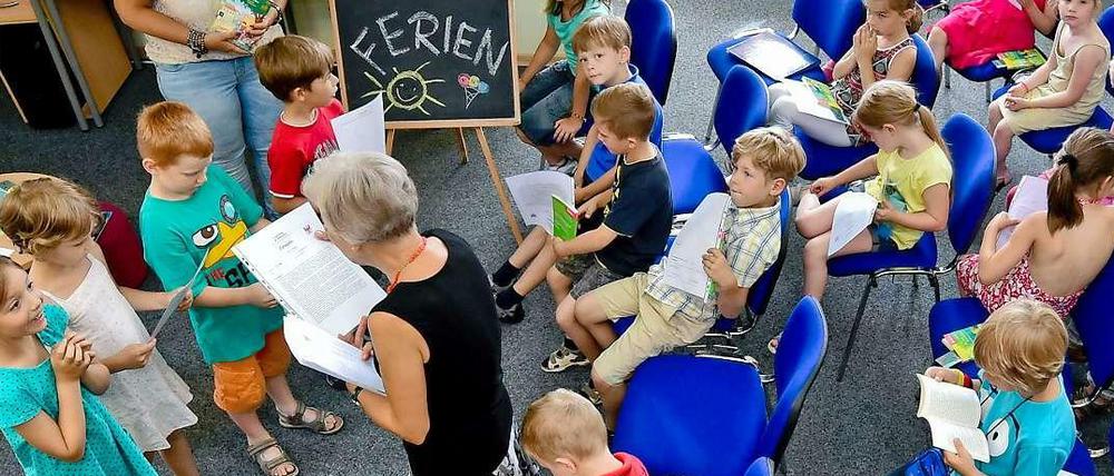 Lehrerin verteilen Zeugnisse an Grundschüler