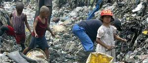 Philippinische Kinder durchsuchen eine Müllhalde nach brauchbaren Materialien.