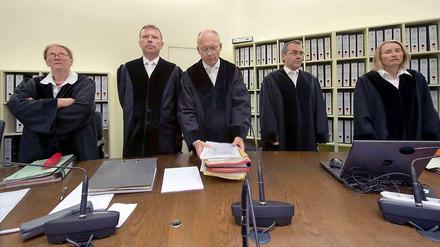 Der Vorsitzende Richter Manfred Götzl (Mitt) und sein Staatsschutzsenat stehen am 22.07.2014 im Gerichtssaal in München (Bayern) hinter der Richterbank.