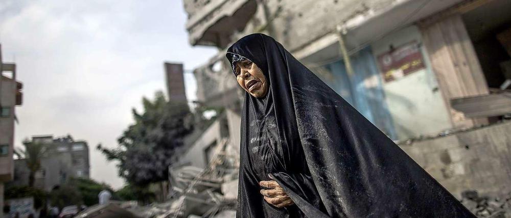 Eine Frau steht im nördlichen Gaza-Streifen vor einem Haus, das bei Luftschlägen beschädigt wurde.