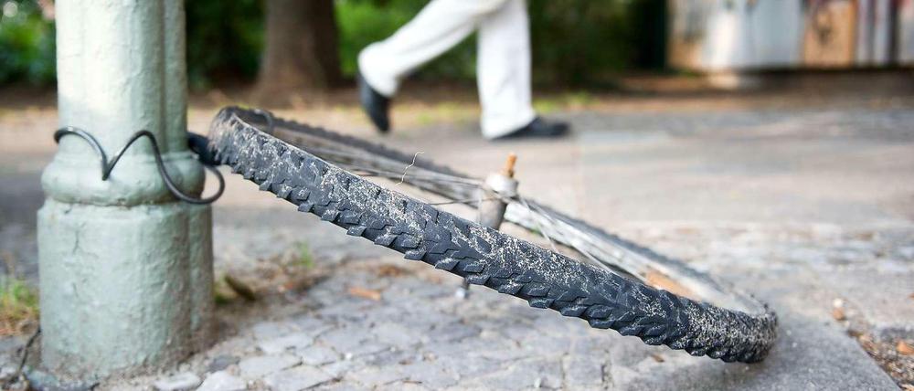 Übriggebliebenes Hinterrad hängt samt Schloss an einem Laternenpfahl in Berlin. Über 70 Räder werden in der Hauptstadt allein an einem Tag geklaut.