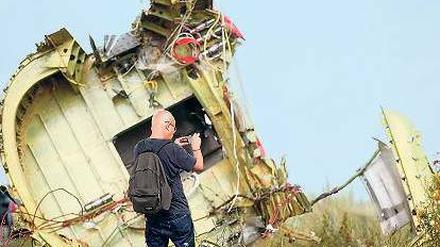 Ein Untersuchungsspezialist macht Aufnahmen am Wrack von MH 17. 