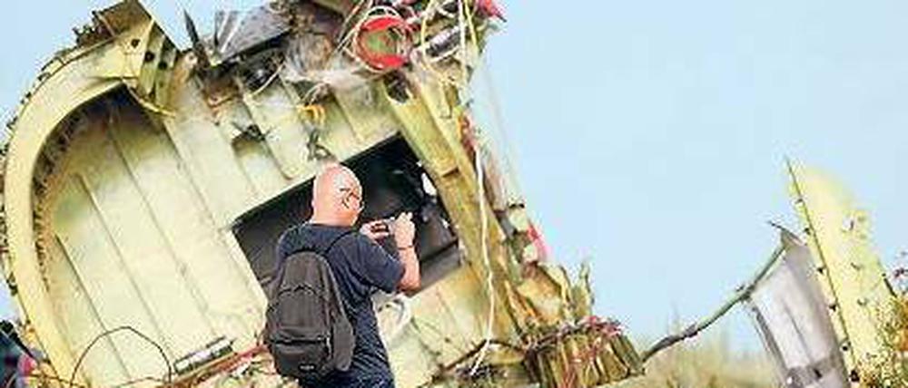 Ein Untersuchungsspezialist macht Aufnahmen am Wrack von MH 17. 