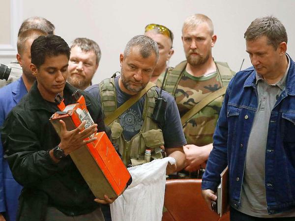 Ein malaysischer Experte hält den Flugschreiber von Flug MH17 in der Hand, der ihm von Separatisten übergeben wurde.