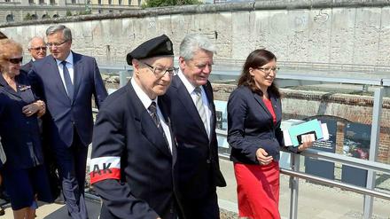 Bundespräsident Joachim Gauck (M.) und der polnische Präsident Bronislaw Komorowski (hinter Gauck) eröffnen in denRuinen der geheimen Staatspolizei (Gestapo) in Berlin, zusammen mit Zeitzeugen, die Ausstellung "Der Warschauer Aufstand 1944". ImHintergrund Reste der Berliner Mauer.