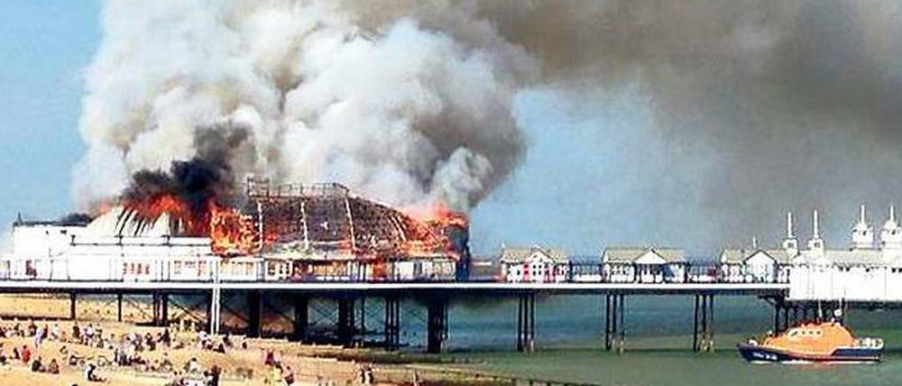 Fassungslos sehen Badegäste am Strand von Eastbourne, wie das Pier abbrennt.