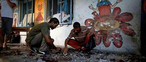 Palästinenser durchsuchen die von einer Granate getroffenen UN-Schule im Gazastreifen.