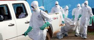 Helfer in Liberia tragen einen Ebola-Toten.