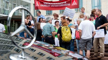 Demonstranten stehen vor dem Landgericht in Stuttgart. Anlass für den Protest ist eine Klage des Autoherstellers Daimler gegen denSüdwestrundfunk wegen einer Reportage über Dumpinglöhne in einem Werk des Autobauers. 