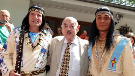 Filmproduzent Artur Brauner posiert mit zwei verkleideten Winnetou-Fans.