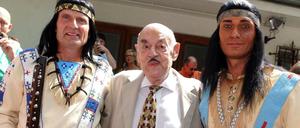 Filmproduzent Artur Brauner posiert mit zwei verkleideten Winnetou-Fans.
