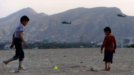 Im Schutz von Nato-Helikoptern. Afghanische Kinder Anfang August 2014 beim Ballspielen. Im Hintergrund die Bergspitze des Wazir Akbar Khan.