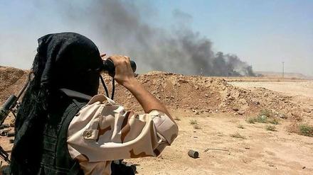 Ein kurdischer Peshmerga-Kämpfer beobachtet aus der Ferne Auseinandersetzungen mit Dschihadisten des "Islamischen Staates" nordöstlich von Bagdad.