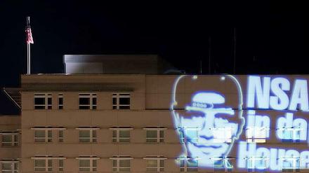 Der Schriftzug "NSA in da House" und das stilisierte Victory-Zeichen werden in der Nacht zum 19. Juli 2014 in Berlin auf die Fassade der nahe dem Reichstag gelegenen US-Botschaft projiziert. Die minutenlange Projektion war eine Aktion des Düsseldorfer Lichtkünstlers Oliver Bienkowski.