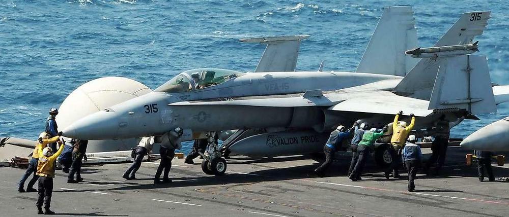 Das Bild der US-Navy zeigt eine F/A-18C Hornet, die auf einem Flugzeugträger für einen Luftangriff auf IS-Terroristen im Irak vorbereitet wird.