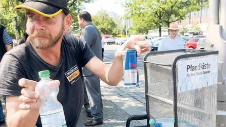 Einfach zugreifen. Am Hardenbergplatz können Passanten ihre Flaschen in speziellen Behältern ablegen, damit Sammler wie dieser 50-Jährige nicht in Papierkörben wühlen müssen. Das Bild entstand im Sommer 2014.