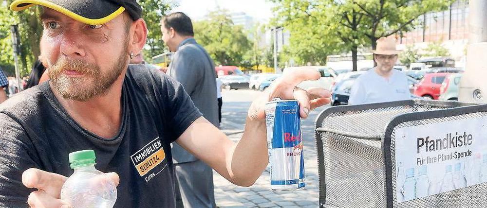 Einfach zugreifen. Am Hardenbergplatz können Passanten ihre Flaschen in speziellen Behältern ablegen, damit Sammler wie dieser 50-Jährige nicht in Papierkörben wühlen müssen. Das Bild entstand im Sommer 2014.