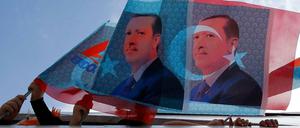 Auf dem Weg zu einer Kundgebung: Anhänger von Premier Erdogan halten Fahnen aus einem Boot.
