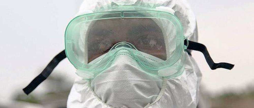 Ganzkörperschutz. Ein Mitarbeiter der Gesundheitsbehörden von Liberia beim Einsatz zur Bergung von toten Ebolaopfern. 