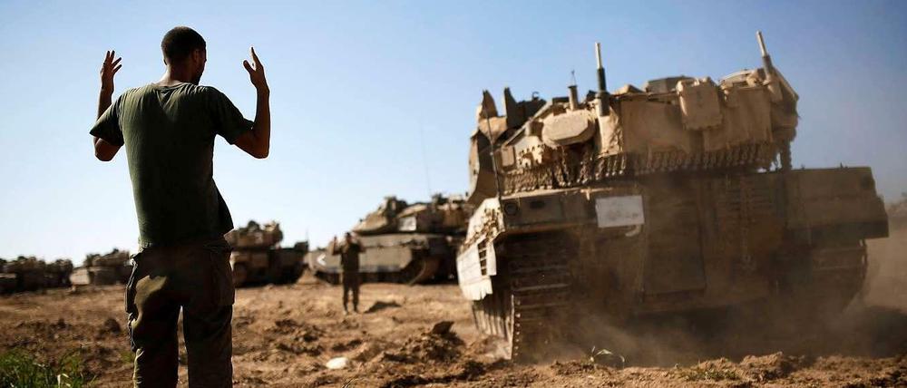Israelischer Soldat weist Panzer im Grenzgebiet zu Gaza ein.