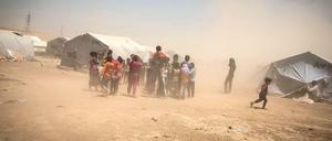 Ein Mitarbeiter der Hilfsorganisation Save the Children spielt mit Kindern in einem improvisierten irakischen Flüchtlingslager. Der Betreuer ist selbst ein Flüchtling - aus Syrien. 