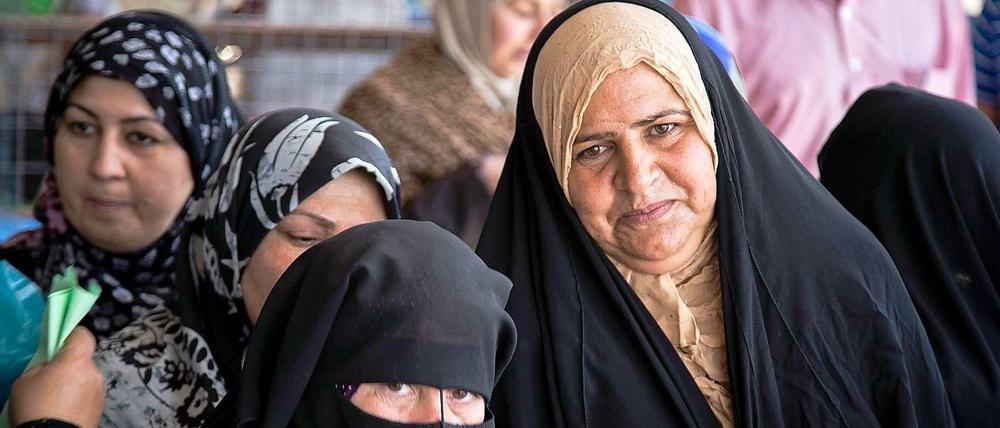 Iraqi women stand in line for relief. Every little space in the kurdish cities in Iraq are needed for refugees now.
