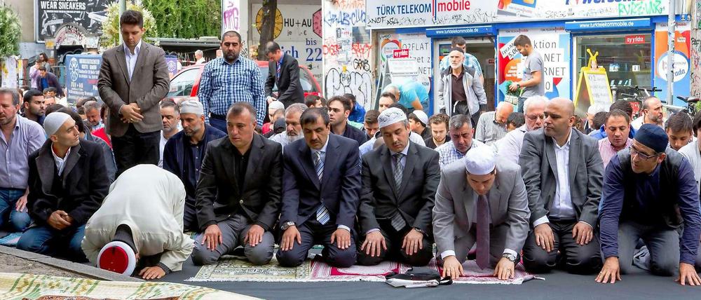 Gläubige Muslime beten in Berlin vor dem Kottbusser Tor, weil ihr in der Nähe gelegen Moschee abgebrannt ist.