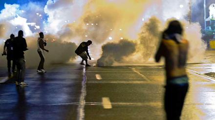 Mit Tränengas und Rauchbomben geht die Polizei gegen Demonstranten vor, die sich der von den Behörden verhängten Ausgangssperre widersetzen.