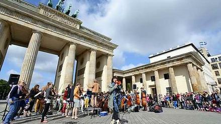 Hereinspaziert! Hier sagt die niederländische Sängerin Ellen ten Damme dem Publikum am Brandenburger Tor das Straßensymphonieorchester mit jungen Nachwuchskünstlern aus Amsterdam an - und singt dann gleich mal weiter.