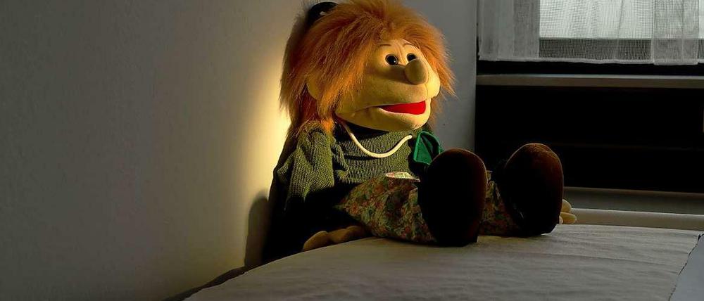 Eine Handpuppe sitzt auf einer Liege in einem Untersuchungsraum in der niedersächsischen Kinderschutzambulanz an der Medizinischen Hochschule Hannover.