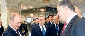 Unter Zeugen. Zur Begrüßung gaben sich Russlands Präsident Putin und sein ukrainischer Kollege Poroschenko die Hand.