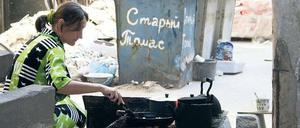 Alltag im Krieg. Tatjana Wladimirowna lebt mit ihrer siebenjährigen Tochter seit einem Monat im ehemaligen Kulturpalast in Donezk. Gekocht wird über einem offenen Feuer im Hof.