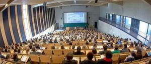 Ein Professor steht vor einem vollen Hörsaal.