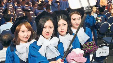 Auch in Deutschland längst zu haben. Südkoreanische College-Studentinnen mit einem ausziehbaren Stativ für das Selfie.