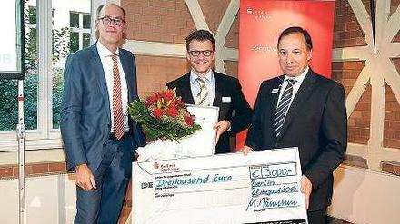 Stolz mit Scheck: FU-Präsident Peter-André Alt (l.) und Michael Jänichen, Leiter Firmenkundengeschäft der Berliner Sparkasse, freuen sich mit Jan Baars (r.). 