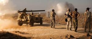 Kurdische Peschmerga-Kämpfer feuern in Richtung von IS-Stellungen. 