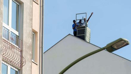 Demo auf dem Dach. Nach wie vor sind auf dem Hostel in der Gürtelstraße in Friedrichshain Flüchtlinge zu sehen. Bis zu neun sind es, die dort ihren Hungerstreik fortsetzen. 