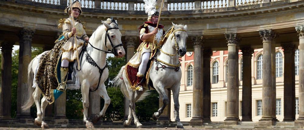 Olympisches Dressurreiten? Na, fast. Wolfgang und Diana Krischke posieren in historischen Kostümen auf ihren Pferden vor den Kolonnaden in Sanssouci. Zur Wiedereröffnung der sanierten Kolonnaden soll vor der historischen Kulisse am 11. September eine barocke Pferdeoper mit 24 Tieren stattfinden – und 2024 vielleicht Olympia.