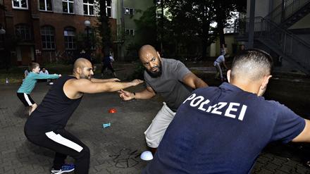 Der Ernst des Strebens. Sozialarbeiter Yousef Ayoub, Ehrenamtler Ferris Jaddou und die Polizei (von links) beim Training im Hof des Flüchtlingsheims „Haus vom Guten Hirten“.