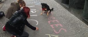 Mutmacher. Hier malen Unterstützer ihre Solidaritätsbekundungen auf den Gehweg vor dem Hostel in der Gürtelstraße, das war Dienstag vor einer Woche. Jetzt wurde die Mahnwache 100 Meter weiter verlegt, damit sich die Leute da unten und die auf dem Dach nicht womöglich gegenseitig hochschaukeln.