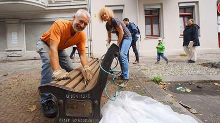 An die Bänke, fertig, los. In der Nähe des Charlottenburger Klausenerplatzes machen die Anwohner Ingo Seubert (links) und Ulrike Beck eine historische Sitzgelegenheit wieder schön.