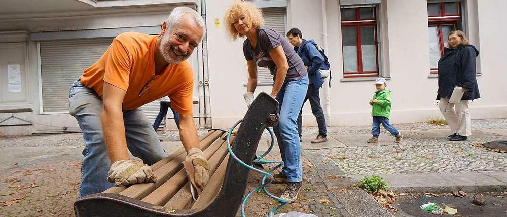 An die Bänke, fertig, los. In der Nähe des Charlottenburger Klausenerplatzes machen die Anwohner Ingo Seubert (links) und Ulrike Beck eine historische Sitzgelegenheit wieder schön.