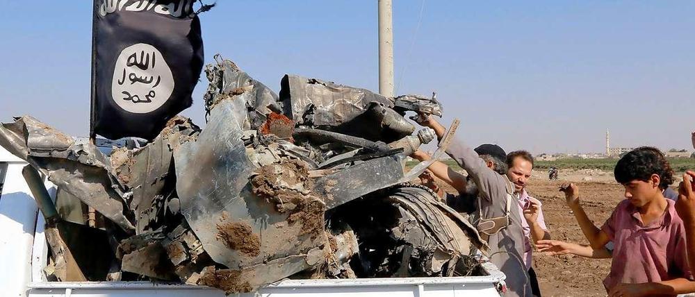 IS-Anhänger präsentieren angebliche Wrackteile eines syrischen Kampfjets.